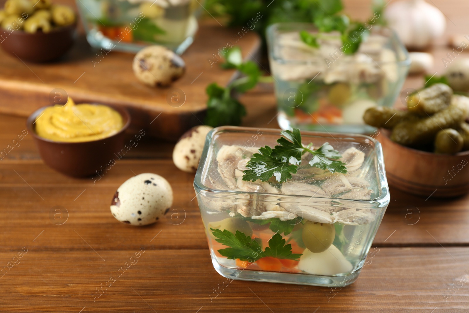 Photo of Delicious aspic with meat and vegetables served on wooden table