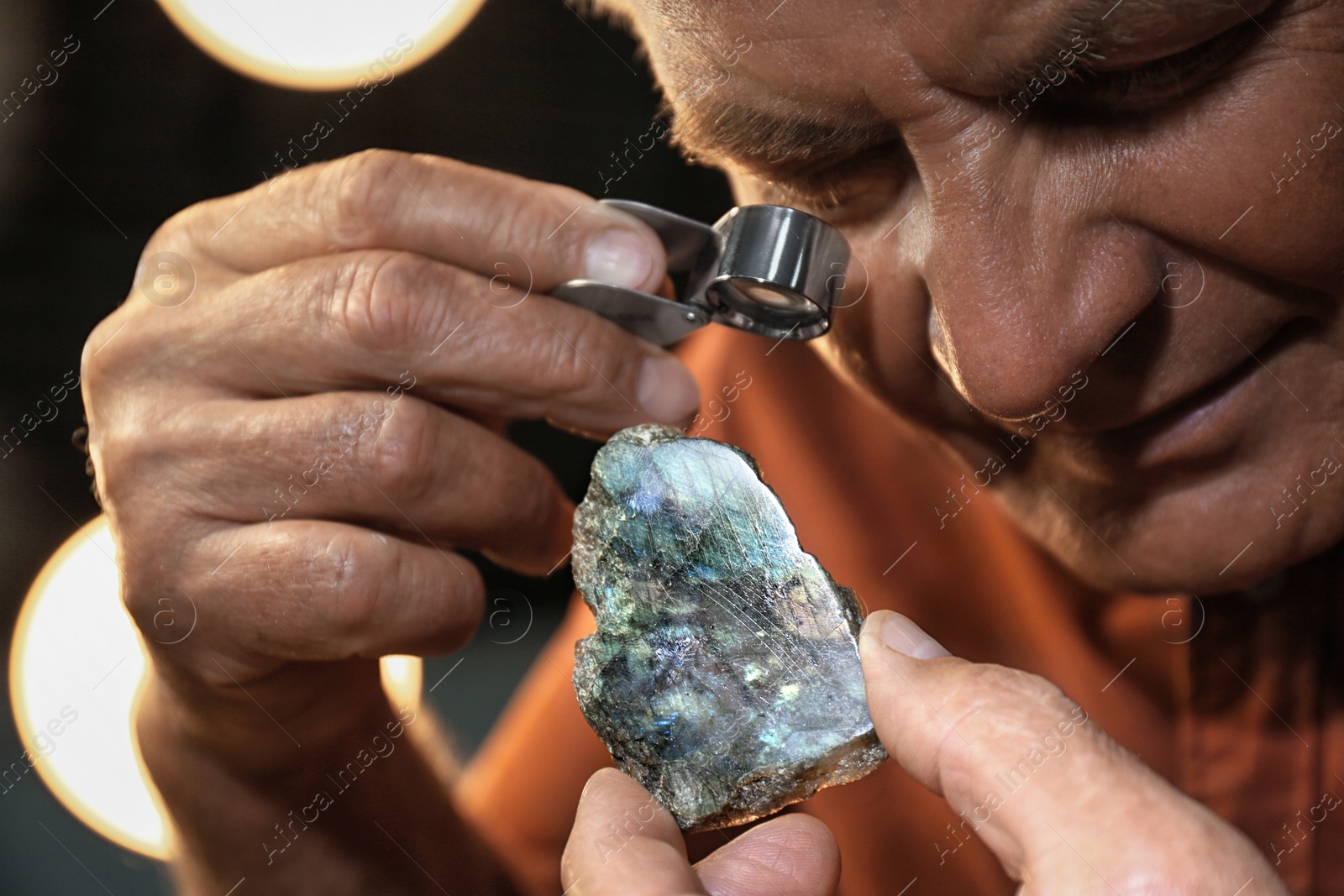 Photo of Professional jeweler working with beautiful labradorite, closeup