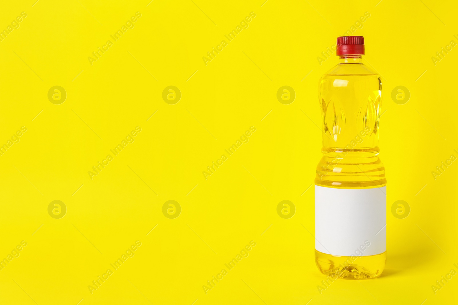 Photo of Bottle of cooking oil on yellow background. Space for text