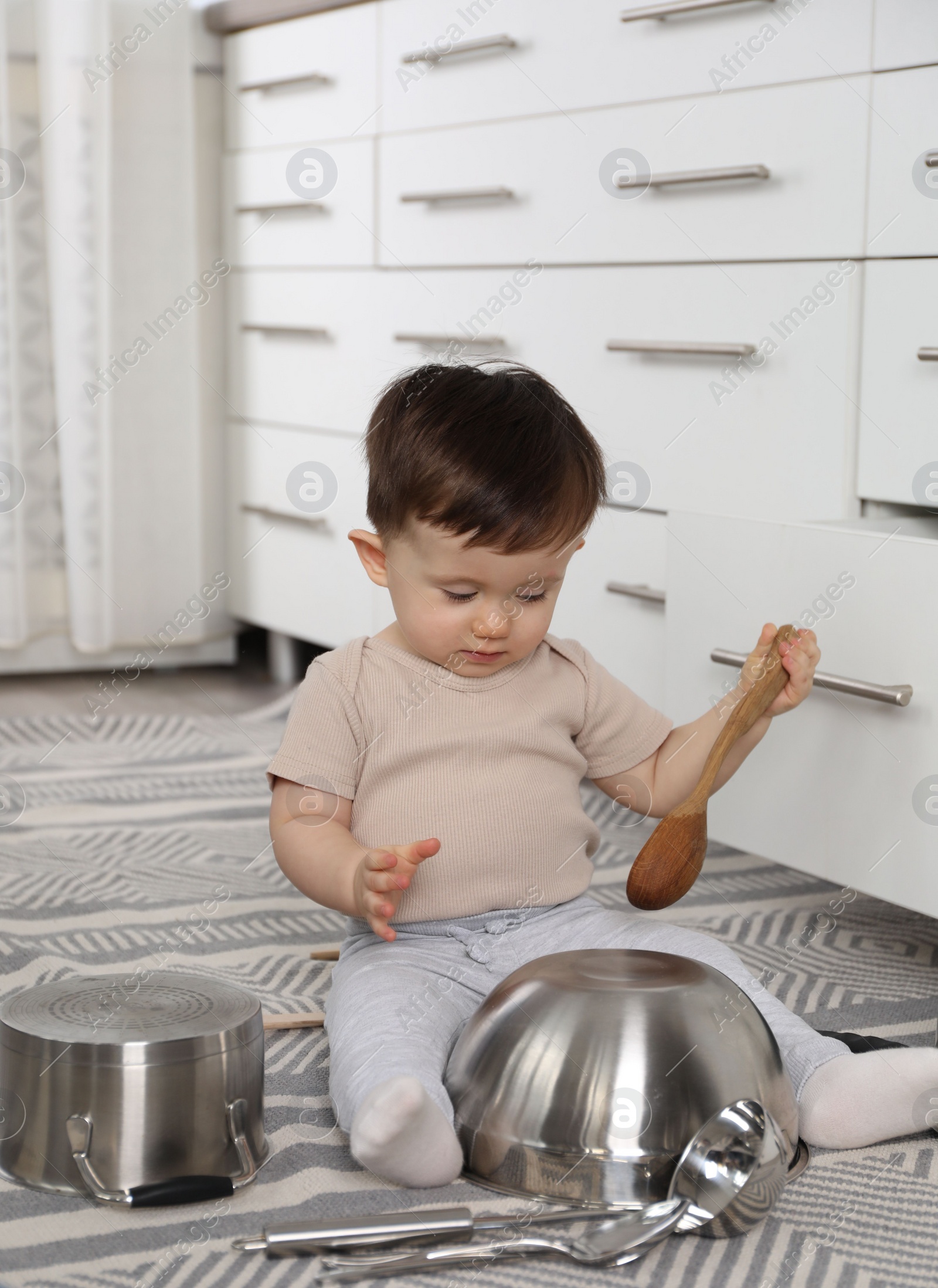 Photo of Cute little boy with cookware at home