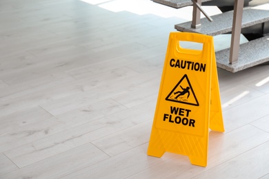 Photo of Safety sign with phrase Caution wet floor near stairs. Cleaning service