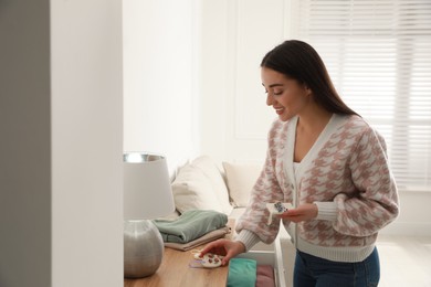 Young woman with scented sachets in room