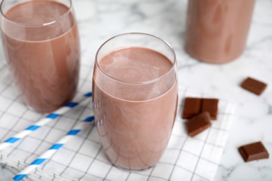 Photo of Delicious chocolate milk in glasses on table, closeup