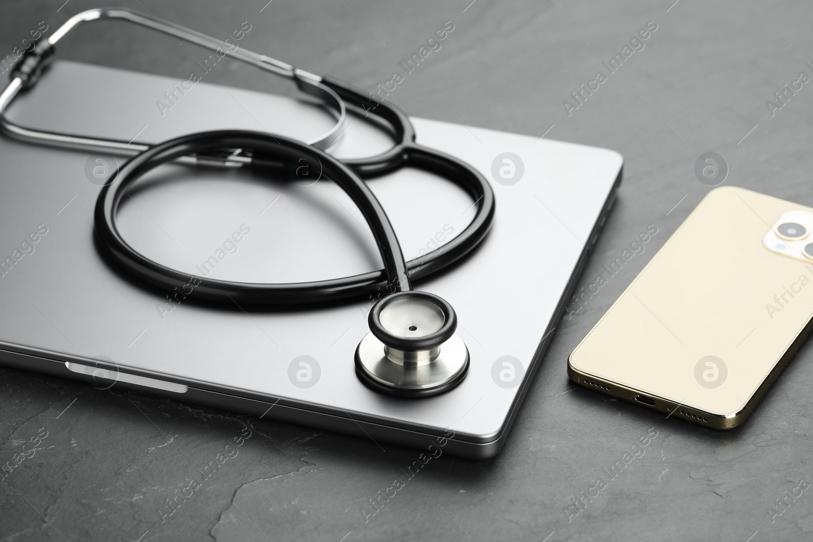 Photo of Modern electronic devices and stethoscope on black table