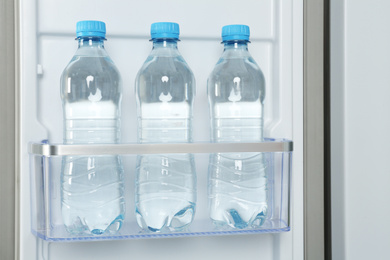 Photo of Bottles of water on shelf in refrigerator