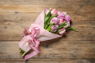 Beautiful bouquet of colorful tulip flowers on wooden table, top view