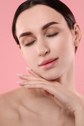 Portrait of beautiful young woman on pink background