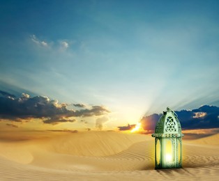 Image of Beautiful Arabic lantern on sand at sunrise, space for text