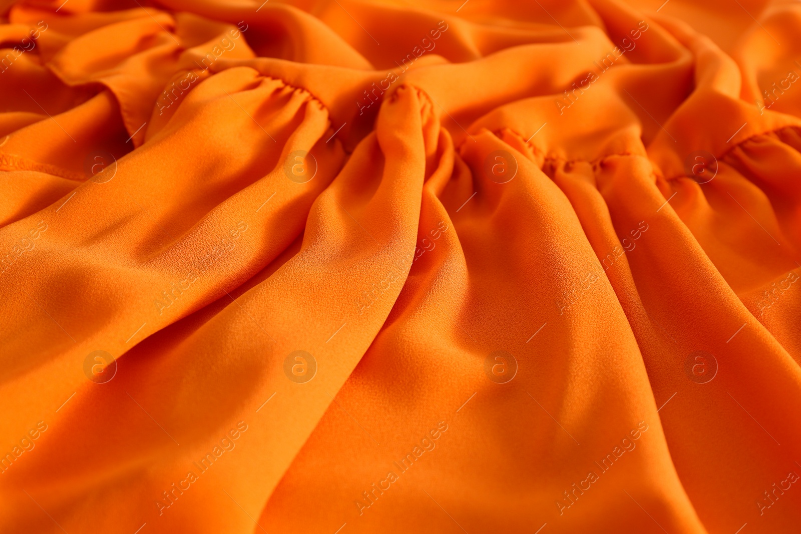 Photo of Texture of orange crumpled fabric as background, closeup view