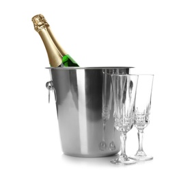Photo of Bottle of champagne in bucket and glasses on white background