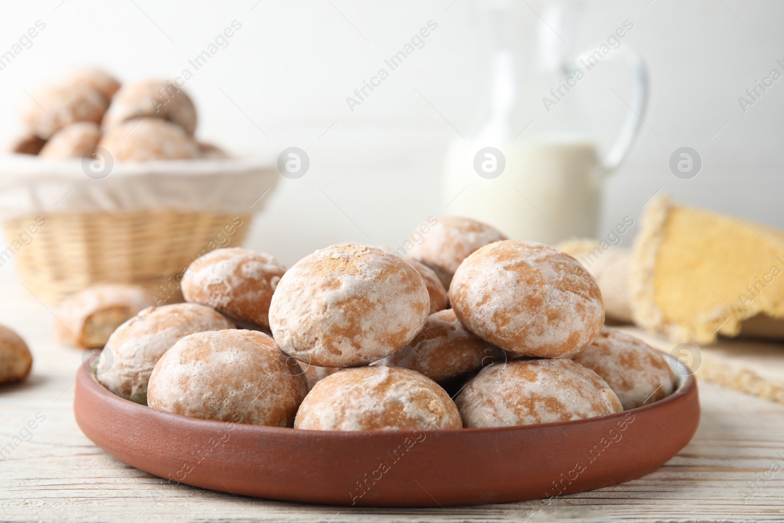 Photo of Plate with tasty homemade gingerbread cookies on white wooden table