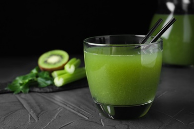 Photo of Glass of fresh celery juice on black table, closeup. Space for text