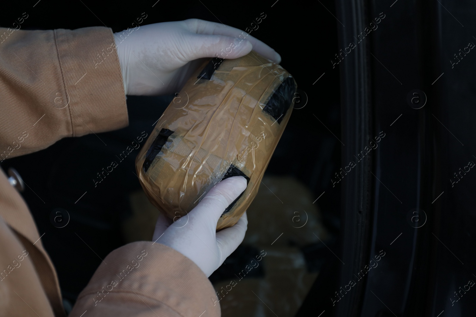 Photo of Man with package of narcotics on dark background, closeup. Space for text