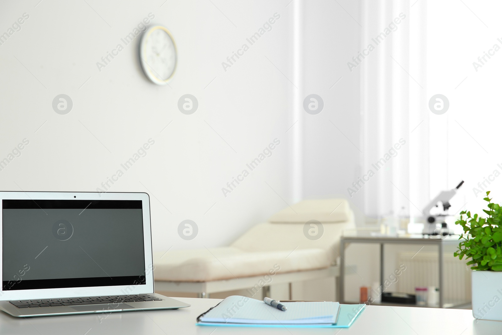 Photo of Modern laptop on desk in medical office, space for text. Doctor's workplace