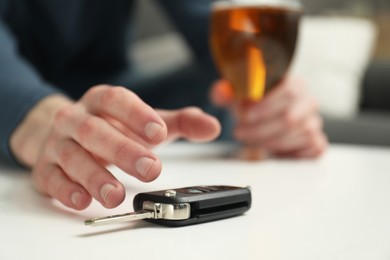 Photo of Drunk man reaching for car keys indoors, closeup. Don't drink and drive concept