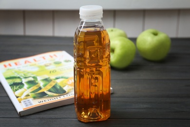 Photo of Bottle of fresh apple juice on wooden table