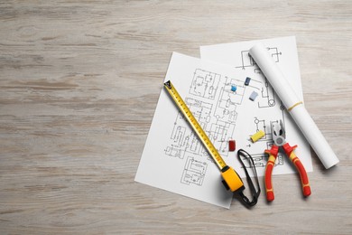 Photo of Wiring diagrams and tools on white wooden table, flat lay. Space for text