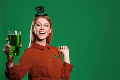 Photo of Young woman with green beer on color background, space for text. St. Patrick's Day celebration