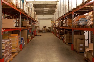 Image of Storage racks with different boxes in warehouse. Logistics concept
