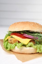 Photo of Delicious burger with tofu and fresh vegetables on white table, closeup