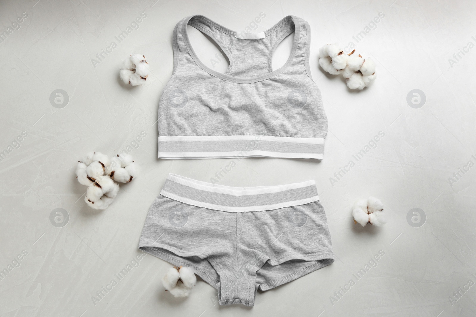 Photo of Sports women's underwear and cotton flowers on light background, flat lay