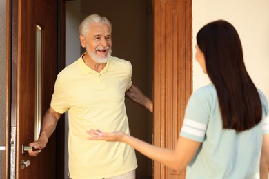 Photo of Friendly relationship with neighbours. Young woman visiting senior man