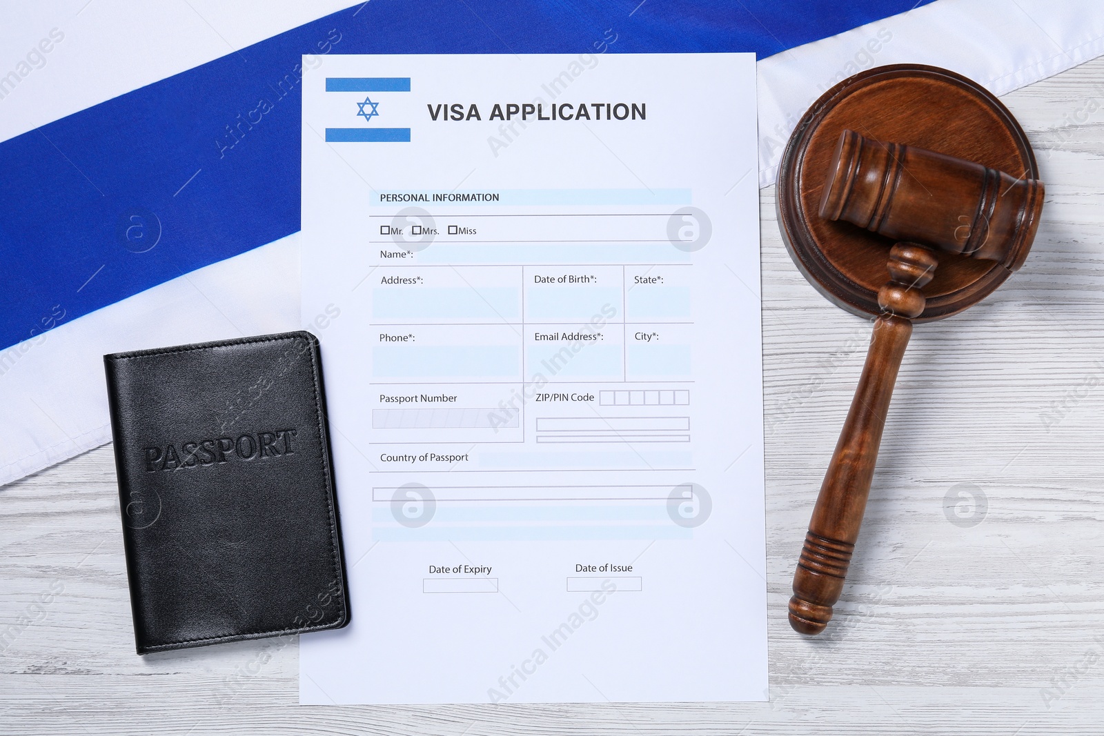 Photo of Immigration to Israel. Visa application form, gavel, passport and flag on white wooden table, flat lay