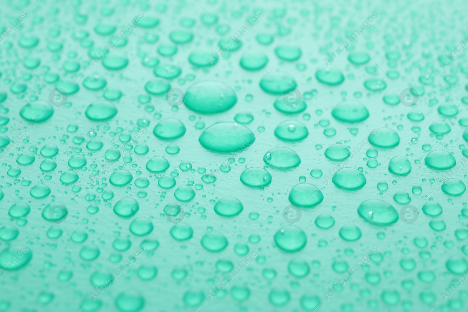 Photo of Water drops on turquoise background, closeup view