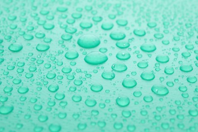 Water drops on turquoise background, closeup view