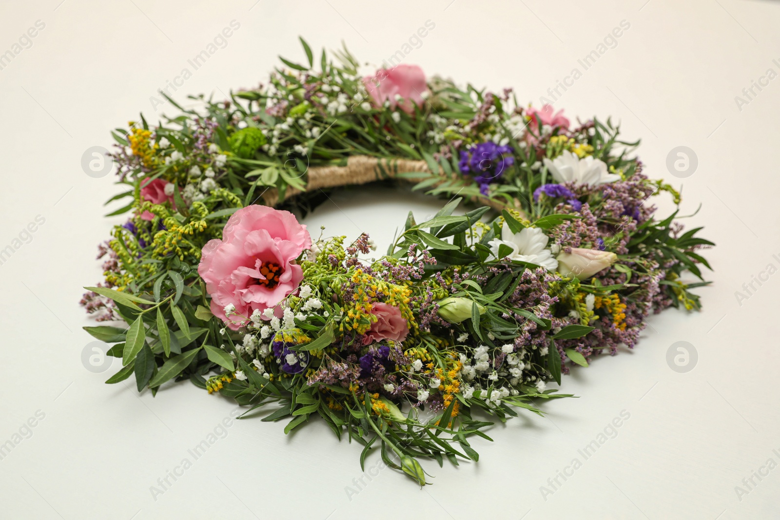 Photo of Wreath made of beautiful flowers on white background