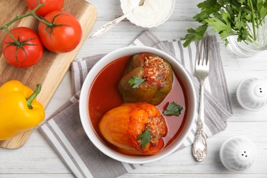 Photo of Delicious stuffed peppers served on white wooden table, flat lay