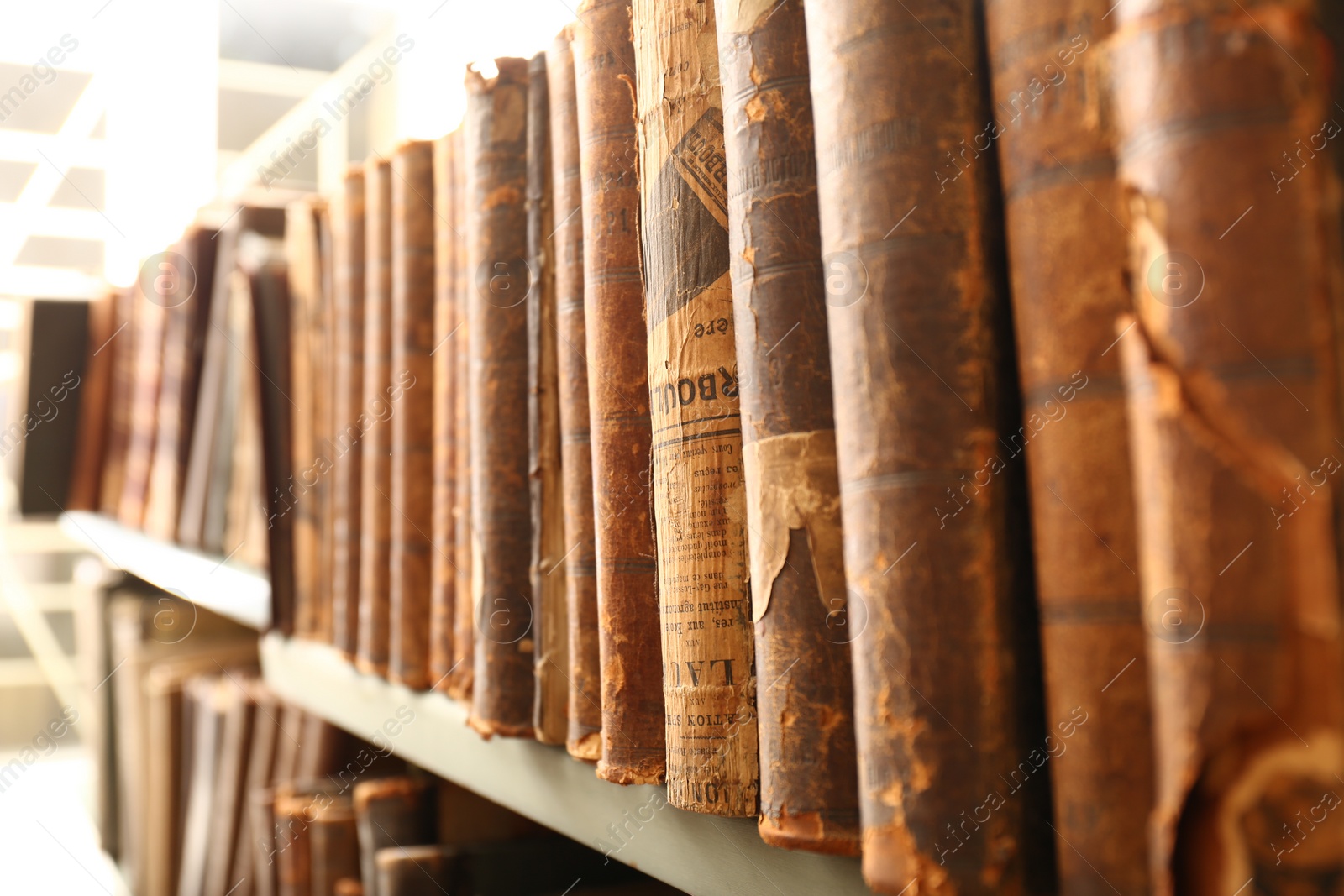 Photo of Different old books on shelf in library, closeup