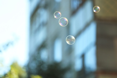 Photo of Beautiful translucent soap bubbles outdoors on sunny day. Space for text