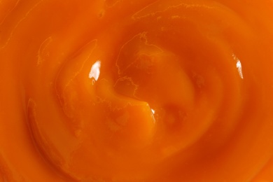 Photo of Delicious orange jam as background, closeup view