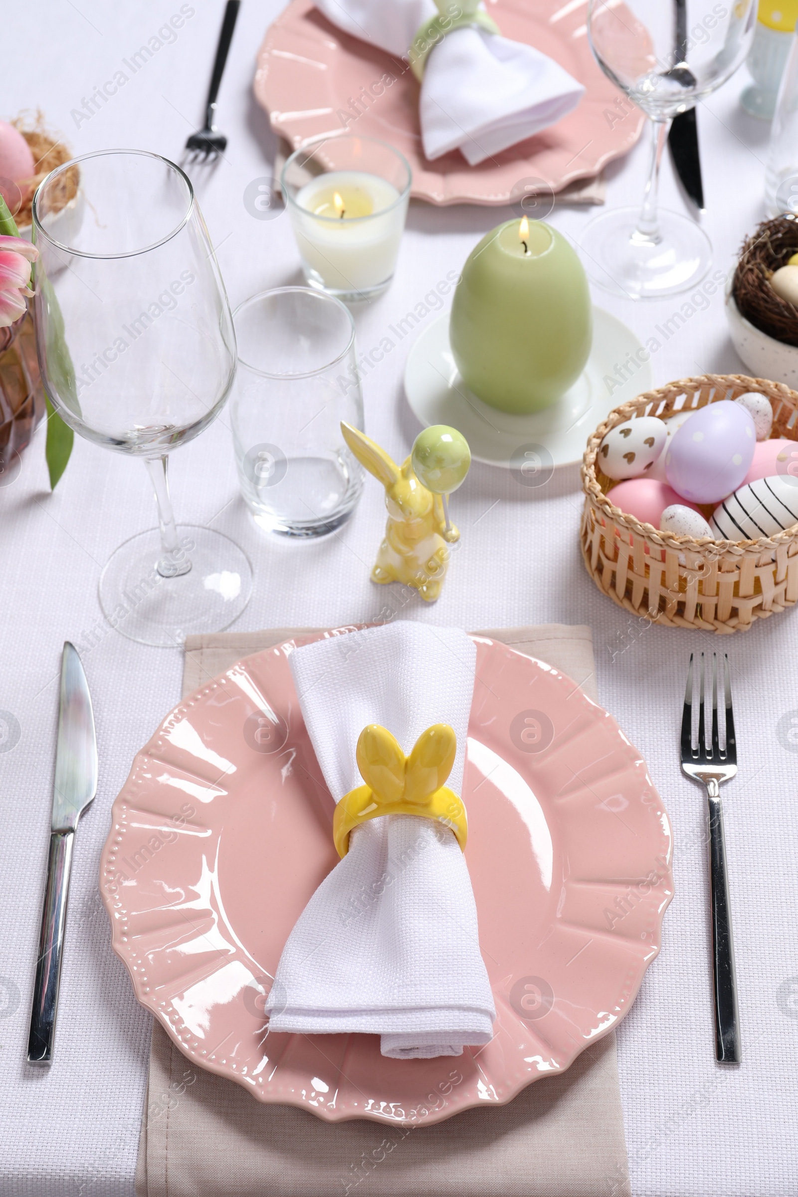 Photo of Festive table setting with napkin ring in shape of bunny ears, closeup. Easter celebration