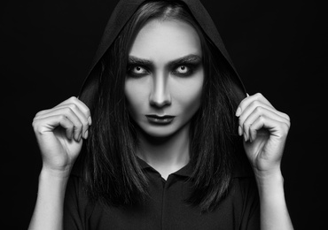 Photo of Mysterious witch with spooky eyes on dark background. Black and white effect