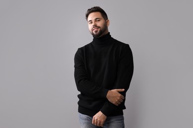 Photo of Handsome man in stylish black sweater on grey background