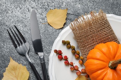 Festive table setting with autumn decor on grey background, flat lay