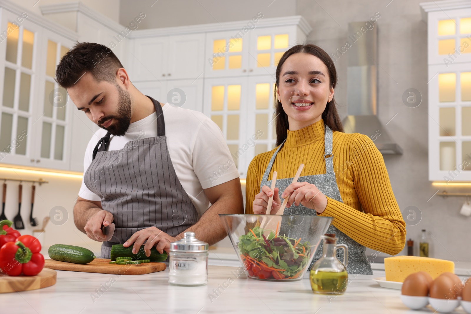 Photo of Lovely young couple cooking together in kitchen