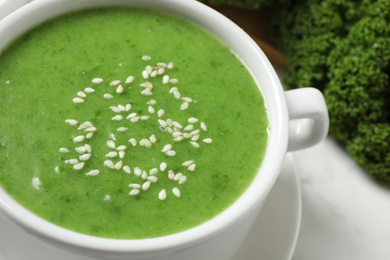 Photo of Tasty kale soup with sesame seeds on table, closeup