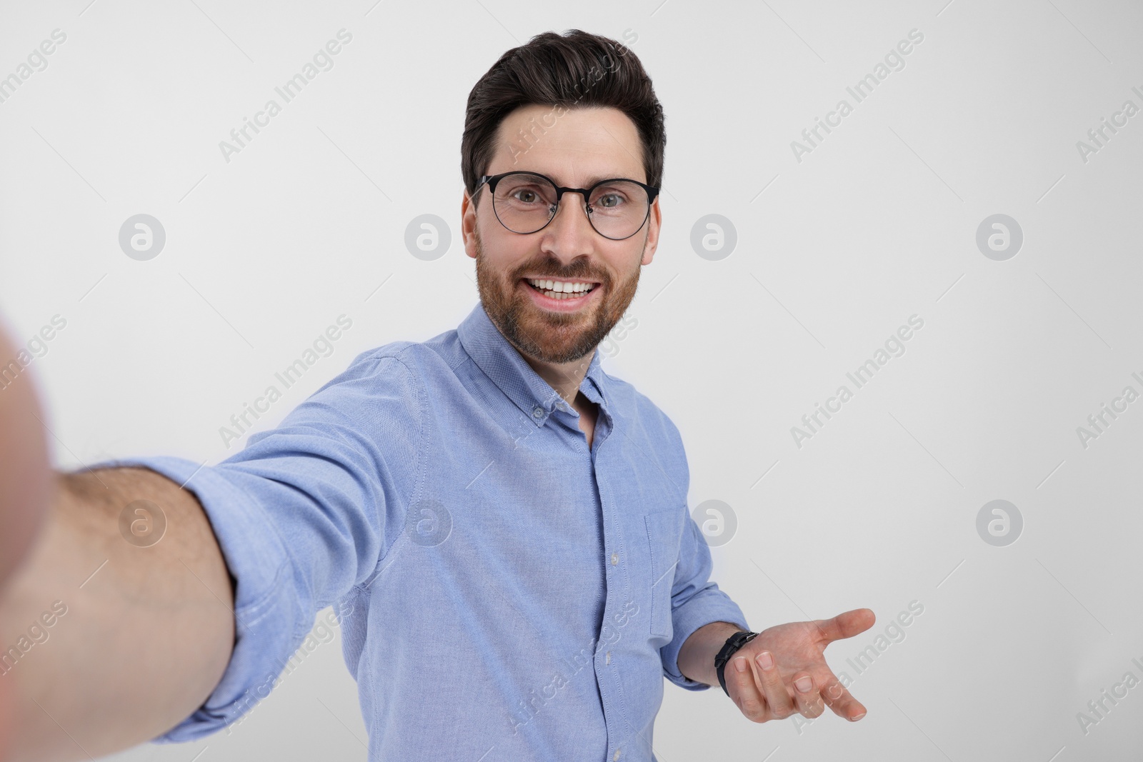 Photo of Smiling man taking selfie on white background