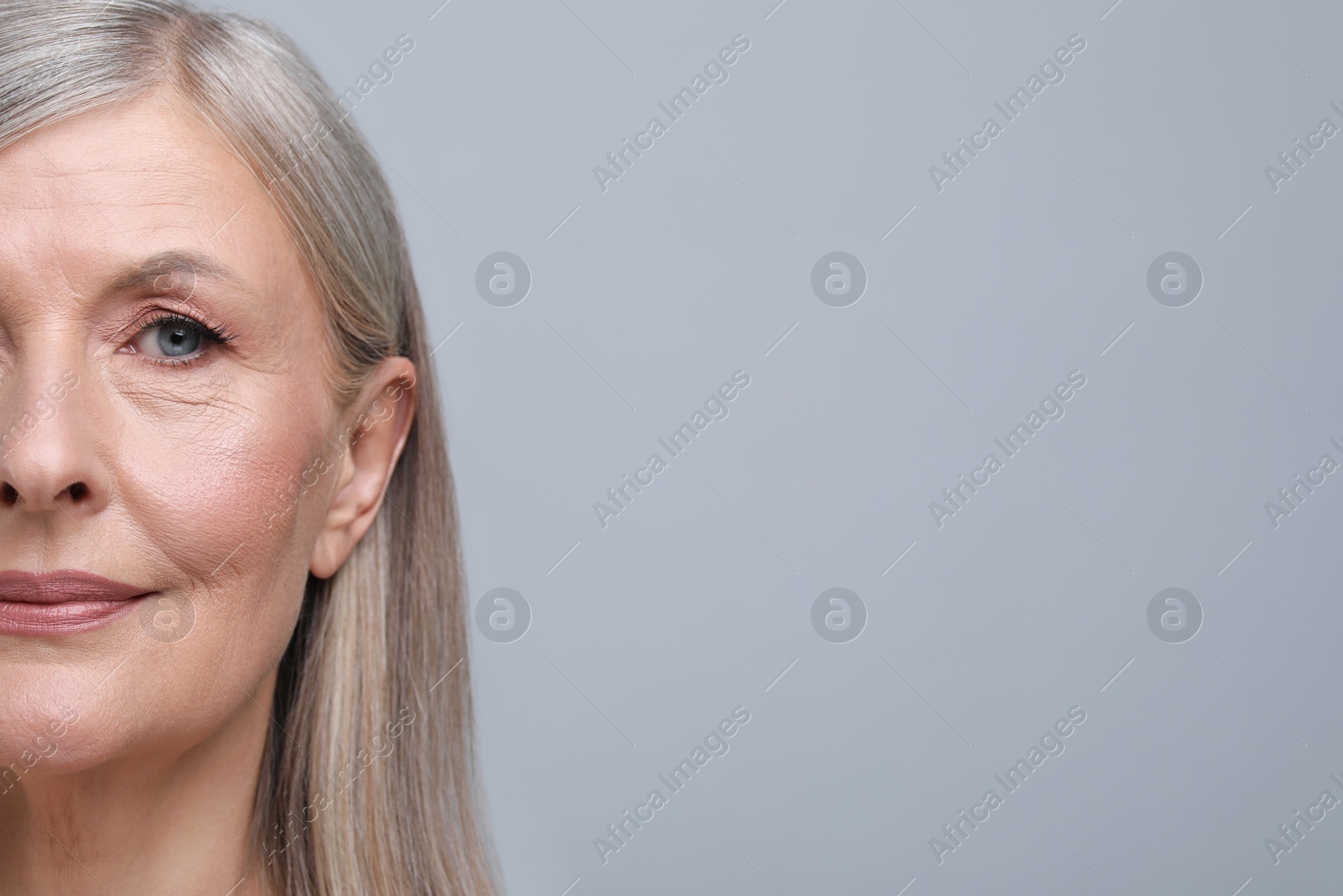 Photo of Portrait of beautiful senior woman on grey background, closeup. Space for text