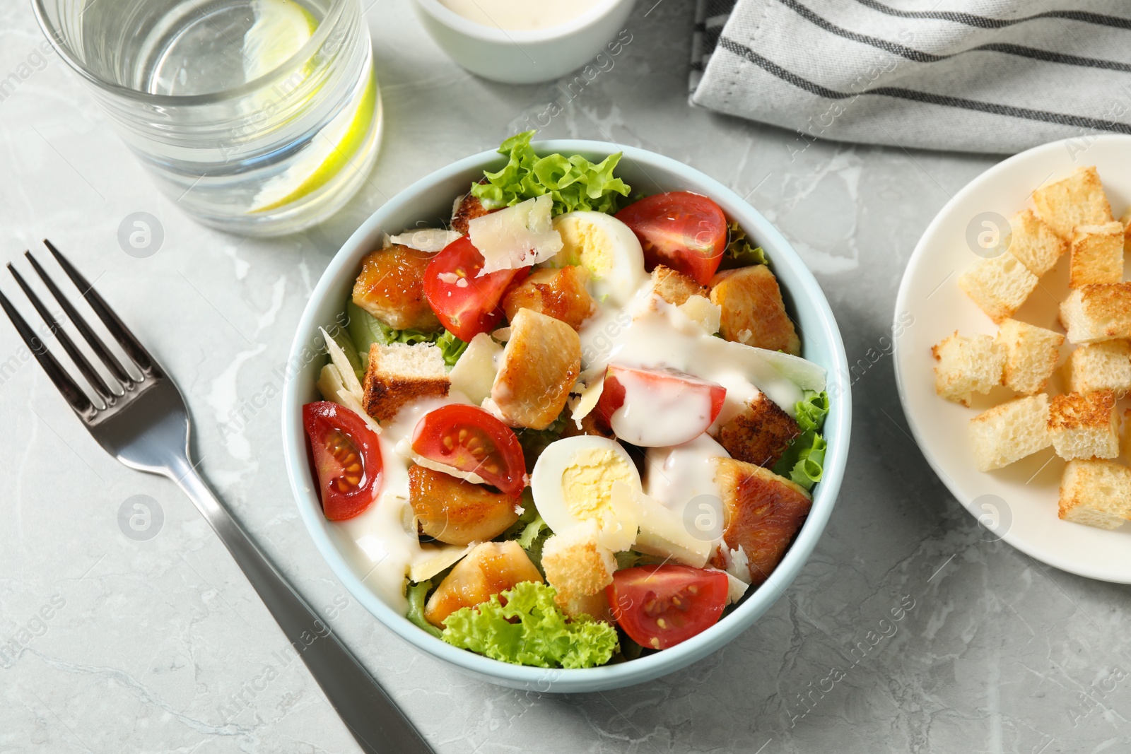 Photo of Delicious fresh Caesar salad on grey marble table, flat lay