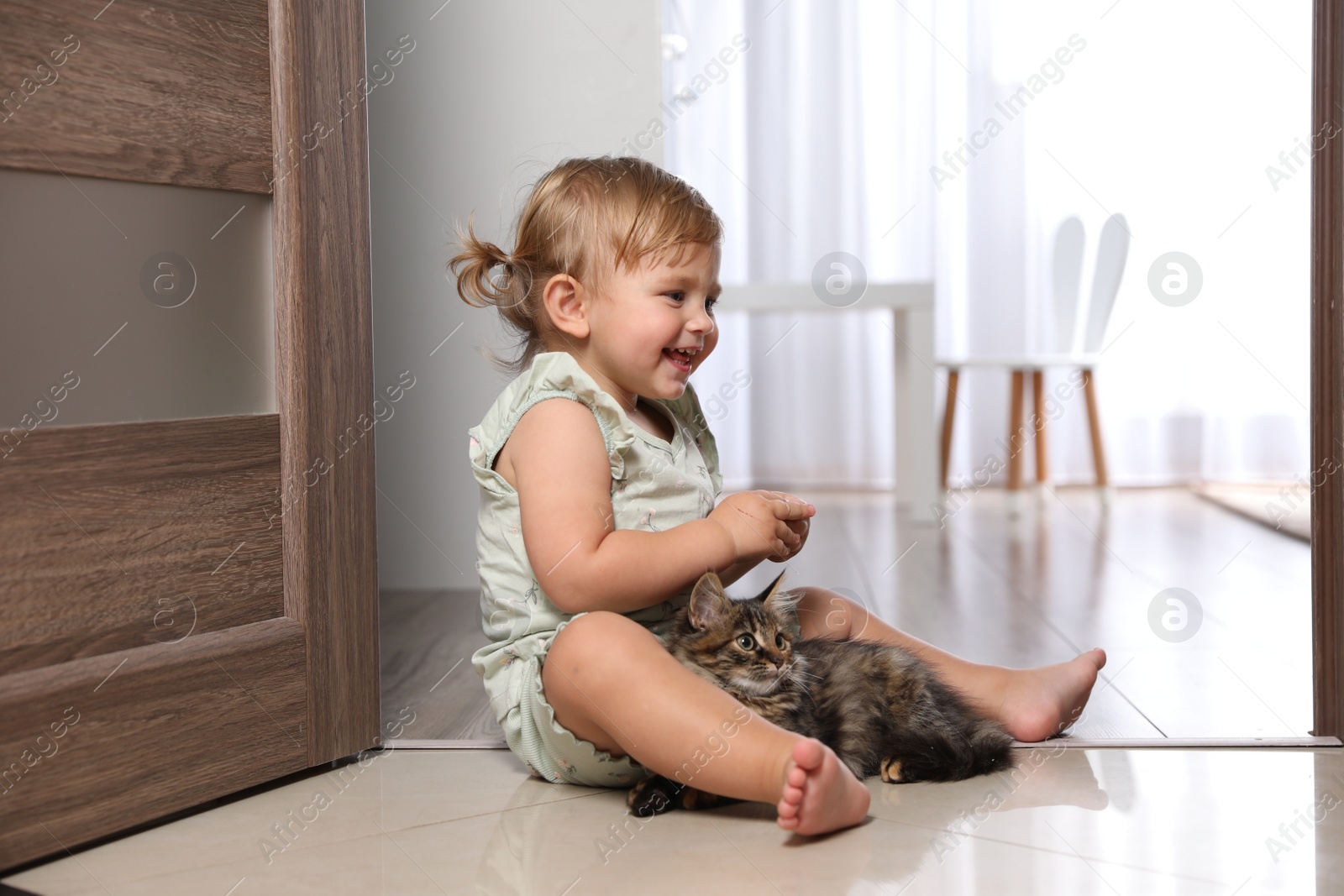 Photo of Cute little child with adorable pet on floor at home