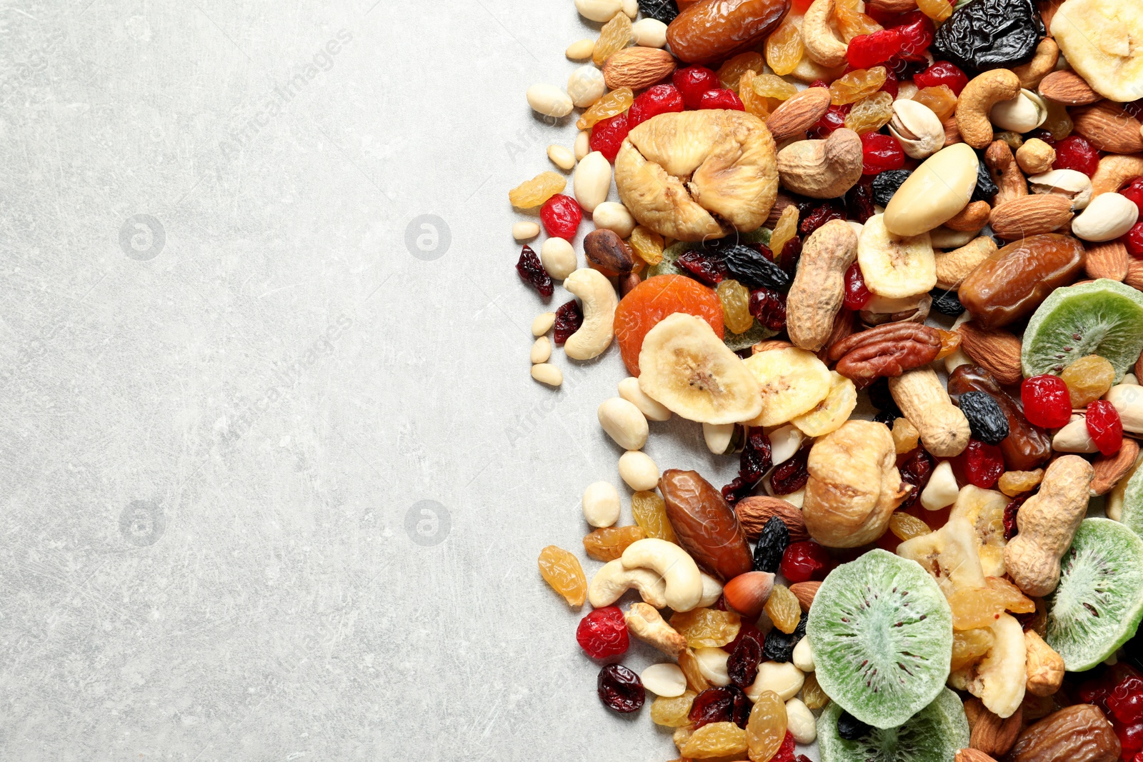 Photo of Different dried fruits and nuts on color background, top view. Space for text