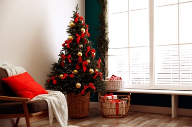 Stylish room interior with decorated Christmas tree