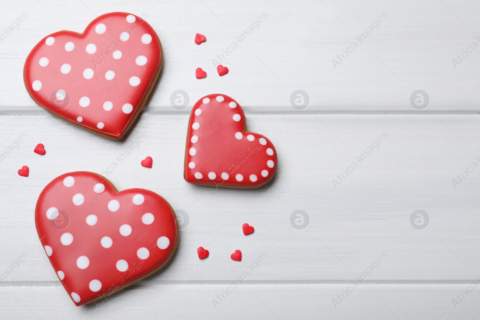 Photo of Heart shaped cookies on white wooden table, flat lay. Space for text. Valentine's day treat