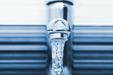 Image of Water flowing from tap on blurred background, closeup