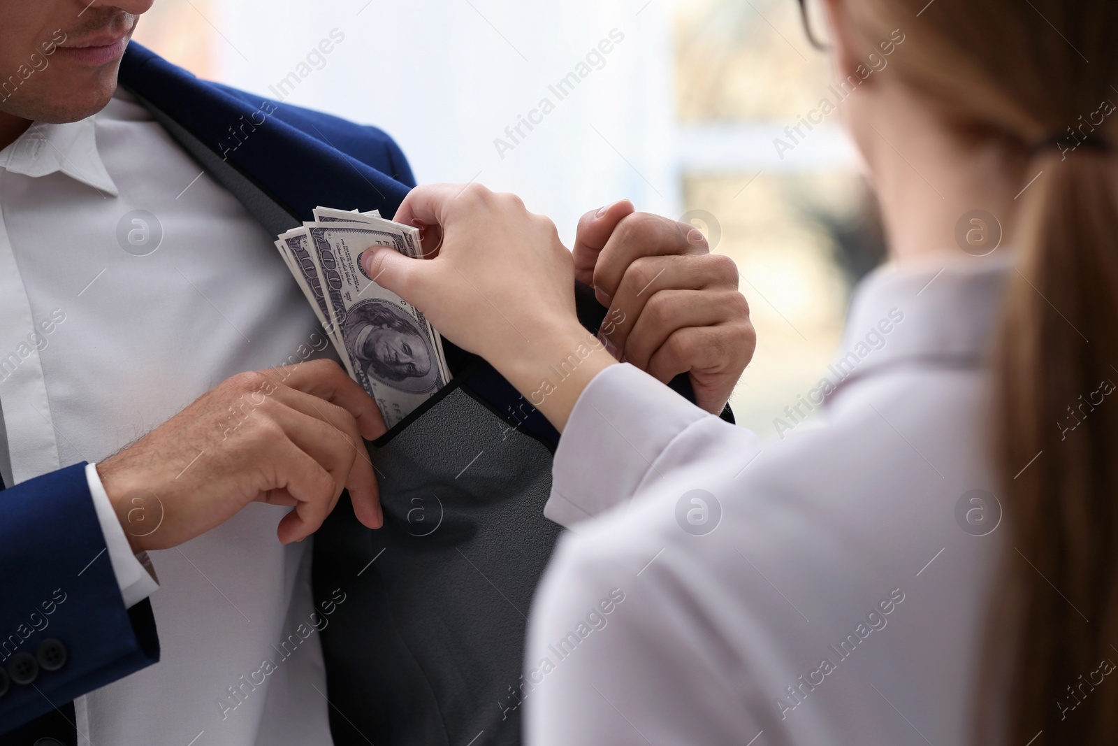 Photo of Woman giving bribe money to man, closeup