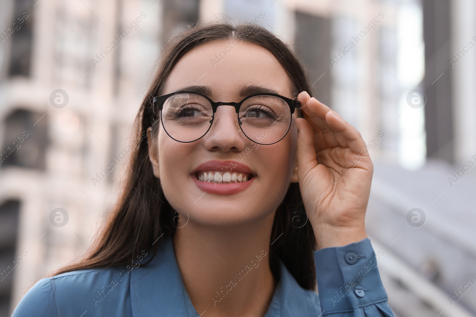 Photo of Portrait of beautiful woman in glasses outdoors. Attractive lady smiling and posing for camera